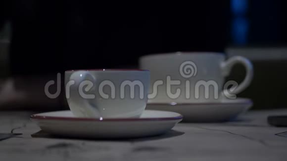 女人的手在绿色屏幕手机上打字背景咖啡杯上的茶站在咖啡馆的桌子上妇女视频的预览图