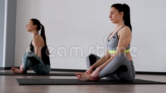 美丽的女孩表演一个练习姿势坐在蝴蝶的姿势普拉提瑜伽深呼吸技术视频的预览图