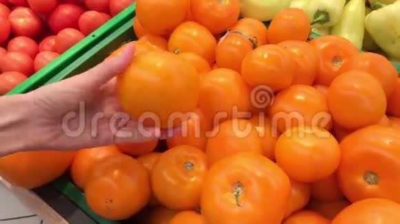 买家选择超市里新鲜的黄熟番茄视频的预览图