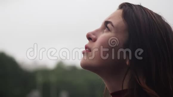 年轻性感女人仰头看雨的特写视频的预览图