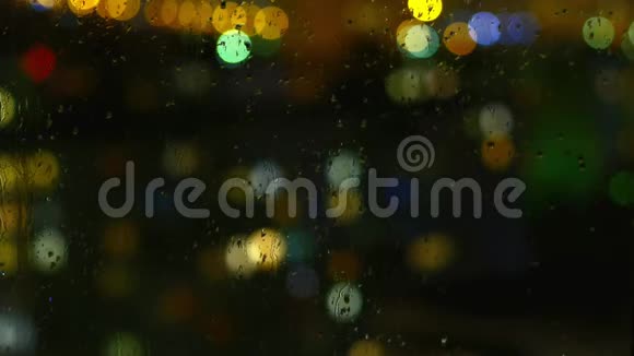 雨天窗面上的雨滴和五颜六色的交通灯视频的预览图