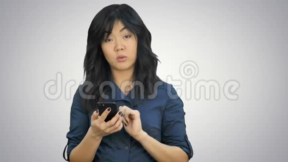 亚洲女商人在智能手机上阅读演示文稿在白色背景下看相机视频的预览图