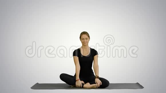 运动迷人的女人练习瑜伽坐在全莲花锻炼Siddhasana姿势锻炼白色视频的预览图