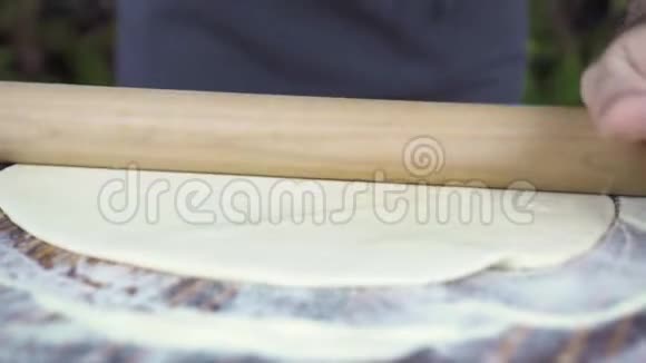 面包师用滚筒滚面团在面包房厨房烘焙蛋糕特写镜头厨师用木头做披萨面团视频的预览图