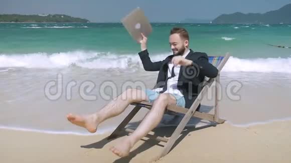 年轻的企业家在风景如画的海滩上玩笔记本电脑视频的预览图