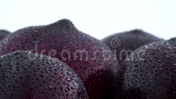 用水滴对成熟紫梅的上部进行宏观拍摄在隔离的转盘上慢慢旋转视频的预览图
