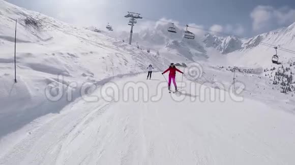 快乐滑雪者在冬季的山坡上滑雪并举起双手视频的预览图