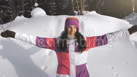 年轻快乐的女人做雪天使视频的预览图