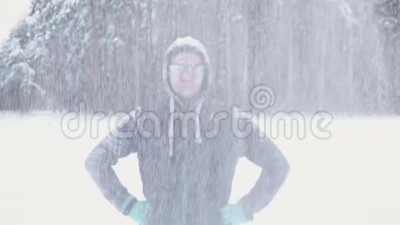 一个冻僵的人在冬天的森林里微笑视频的预览图