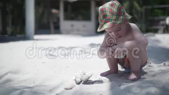 戴帽子的快乐男孩在沙滩上玩耍视频的预览图