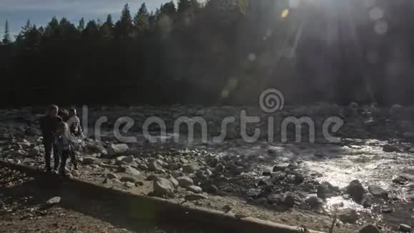人们沿着河上倒下的原木桥走家庭旅行人的环境由山河溪视频的预览图