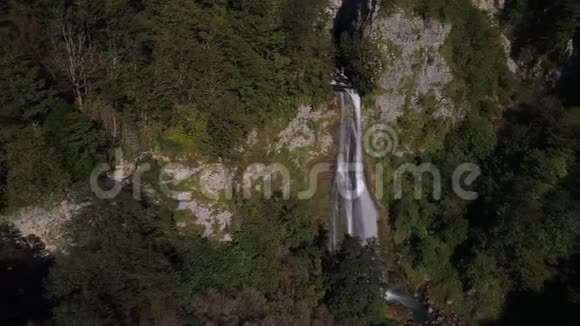 在佐治亚州绿色森林中的瀑布上方飞行的无人机视频的预览图