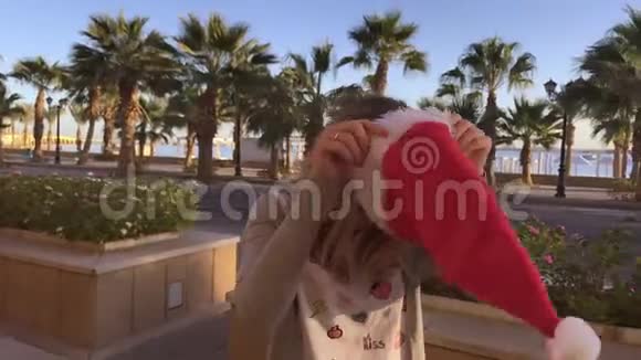 棕榈海咖啡馆戴圣诞帽的年轻漂亮女孩的画像视频的预览图