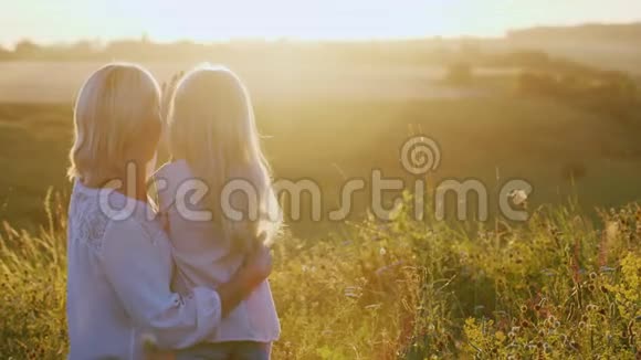 年轻的妈妈一起度过一个周末享受大自然看看美丽的日落视频的预览图