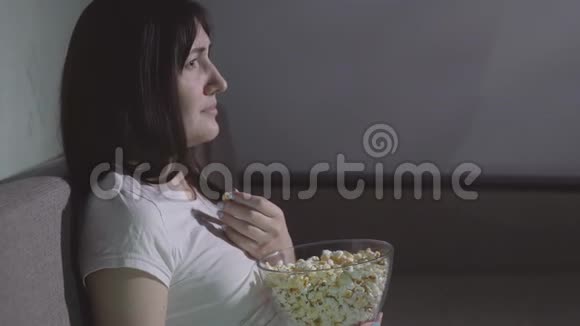 一个年轻漂亮的女孩独自在看恐怖片视频的预览图