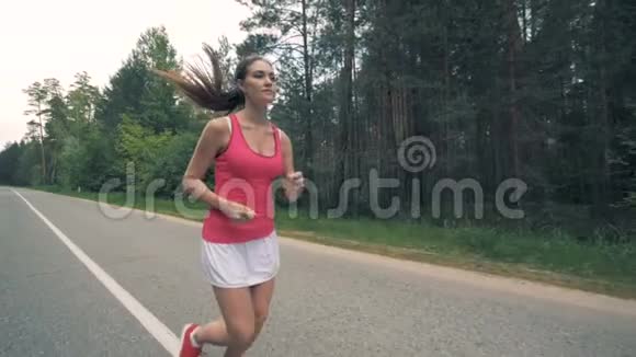 森林之路上有一位年轻女士沿着它奔跑健康苗条的年轻女运动员跑步视频的预览图