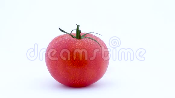 一整个大红番茄和一半的黄色番茄带水滴在转盘上慢慢旋转孤立存在视频的预览图
