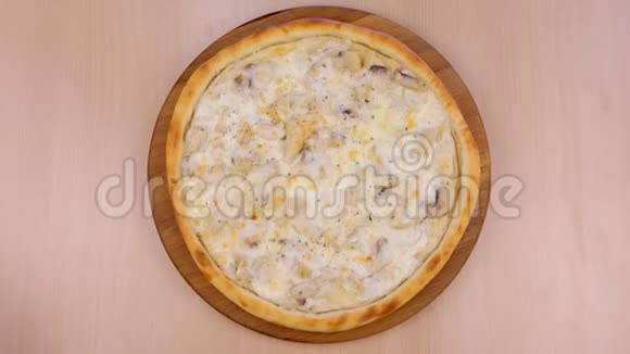 在桌上的木板上放着蘑菇香槟和奶酪的披萨特写俯视图视频的预览图