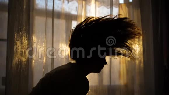 清晨站在窗边的女孩她抬起头头发长出了愉快和愉快的心情视频的预览图