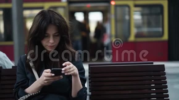 迷人的年轻游客在柏林中央火车站的长椅上发短信视频的预览图