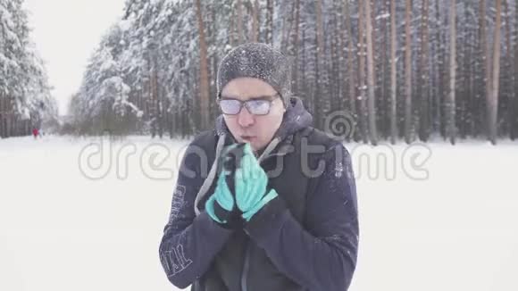 冬天的公园里冷得冻人戴着眼镜搓手霜冻视频的预览图