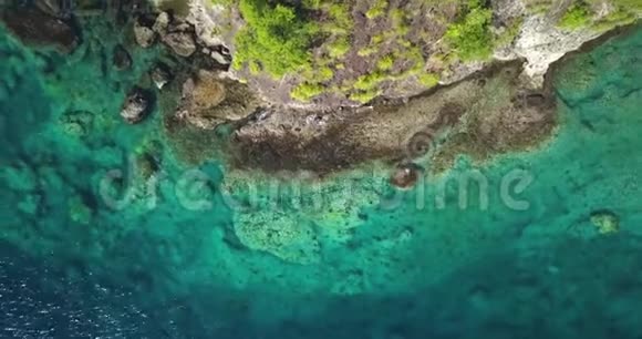 鸟瞰热带天堂海岸线在一个加勒比岛上绿松石水和小浪冲击岩石视频的预览图
