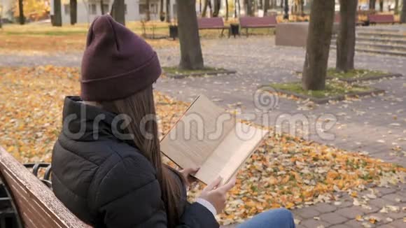 秋天公园的年轻漂亮女孩在看书视频的预览图