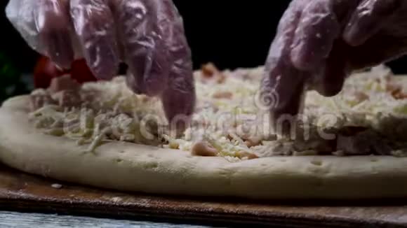为厨师的手在透明手套接触未烘焙的披萨在黑色背景烹饪概念框架男子视频的预览图
