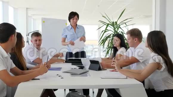 女老板在大白桌后面与年轻的合作者会面进入现代董事会视频的预览图