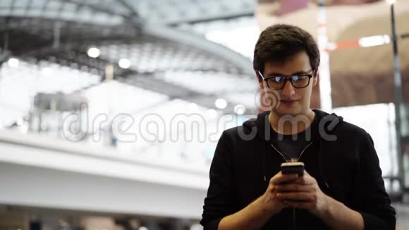 戴眼镜的年轻游客发短信和快乐视频的预览图