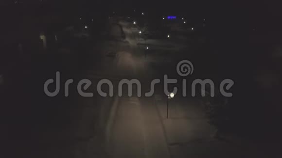 冬天的夜晚路灯照亮了白雪覆盖的小径剪辑冬季公园附近路灯的俯视图视频的预览图