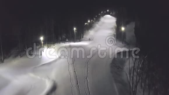 夜晚覆盖着雪的公园顶景剪辑公园的城市小巷被雪堆覆盖空的灯光照亮视频的预览图