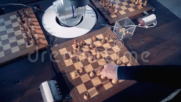 人类和机器人的手臂在下棋时移动棋子视频的预览图