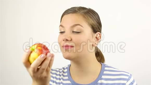 美丽的年轻女子闻着红苹果视频的预览图