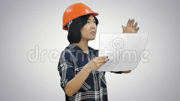 女工程师带着一条细边和建筑计划试图和一个遥远的白人交谈视频的预览图