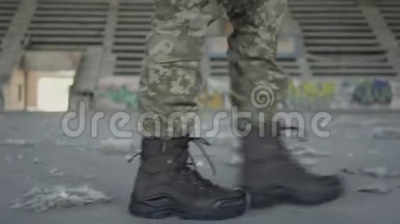 漂亮的年轻女子穿着军装在尘土飞扬的肮脏废弃的大楼里慢慢地走着手里拿着高跟鞋视频的预览图