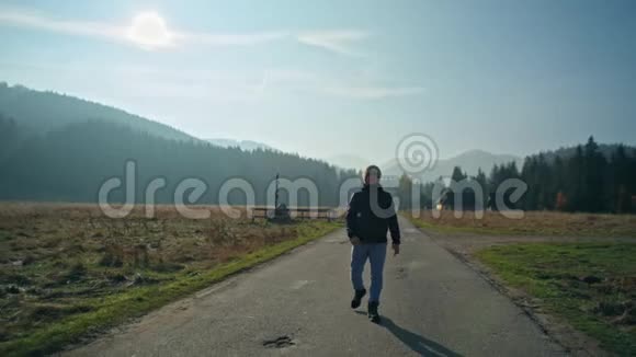 青年走在秋天的路上山与天视频的预览图