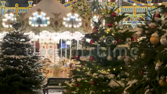 圣诞树装饰着城市在背景下旋转旋转旋转木马孩子们骑在上面节日视频的预览图