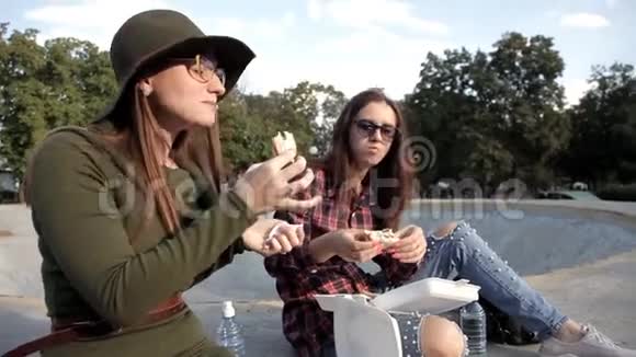 有趣的女孩花时间在公园里笑着吃三明治喝水三明治日假日视频的预览图