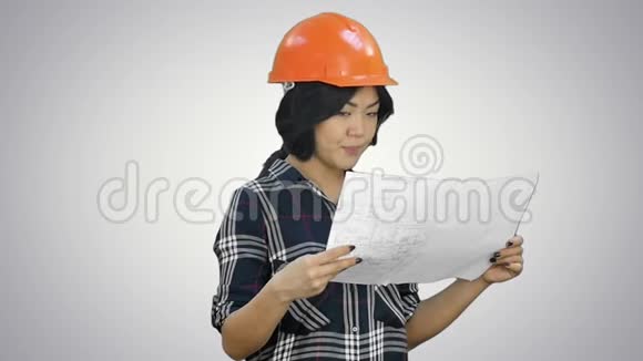 美丽的亚洲女商人拿着蓝图戴着白色背景的安全帽视频的预览图