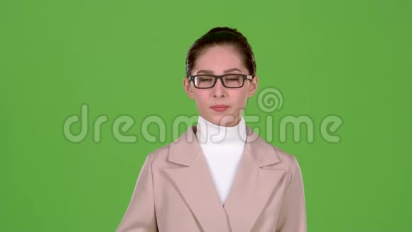 穿着商务服的女孩站在工作室里她头痛得厉害绿色屏幕慢动作视频的预览图