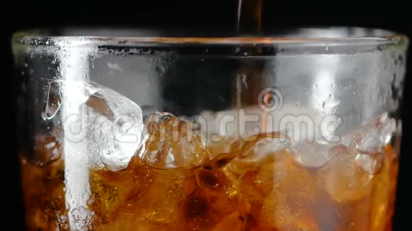 将可乐苏打水根贝混合水和冰块倒入玻璃杯中视频的预览图