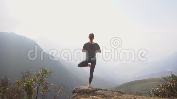 做瑜伽的女人山崖上的树姿视频的预览图