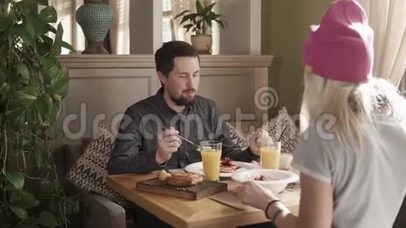 朋友们在餐馆吃早餐吃甜糖浆和牛角面包视频的预览图