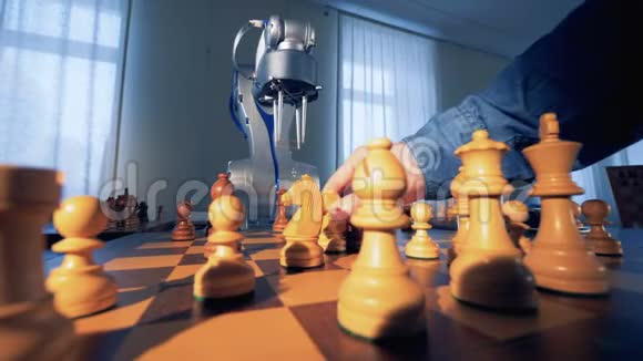 在阳光下一只雄性的手和一只机械的手臂移动着棋子视频的预览图