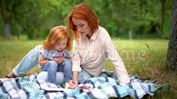 可爱的妈妈和孩子在公园画画视频的预览图