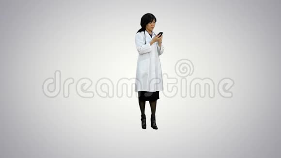 亚洲女医生使用白色背景的智能手机视频的预览图