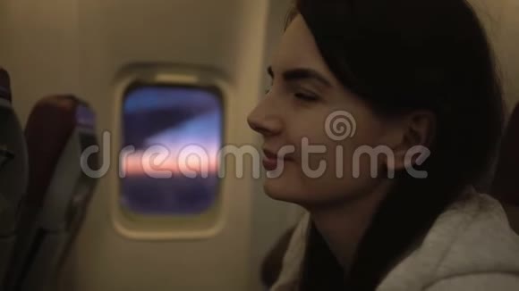 坐在飞机座位上的年轻女子的肖像视频的预览图