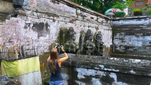 年轻的女摄影师和她的儿子参观巴厘岛上的GoaGajah或大象洞寺视频的预览图
