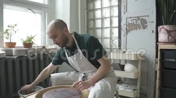 男ceramist的肖像他正在光明工作室开始工作视频的预览图